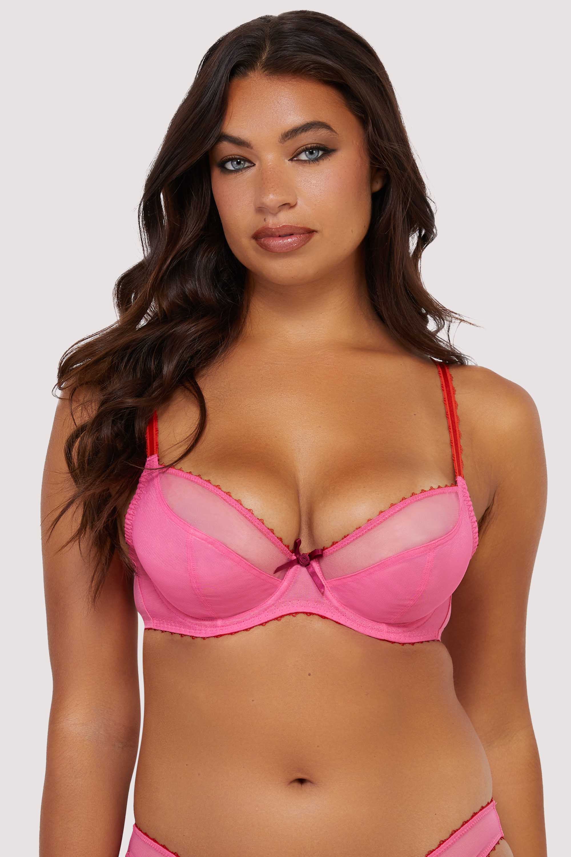 Model wears pink supportive plunge net bra with sheer mesh cups and bow detail.