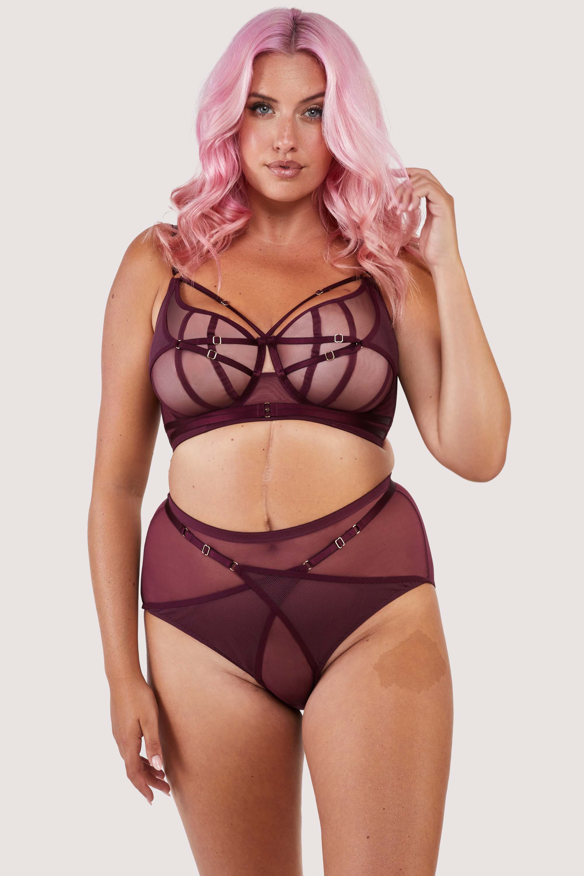 Harness style brief with mesh overlay and visible gold hardware in a deep wine red/purple, worn with a matching bra.