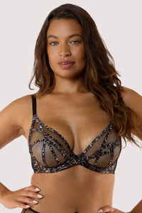 Model wears a leopard print bra, showcasing mesh cups and caged strap detailing for a daring look.