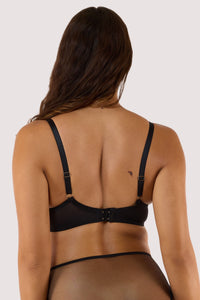 Model shows a back of leopard print bra with caged straps, showcasing a stylish design.
