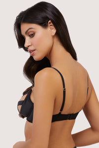 Model shows side view of black bra quarter cup and adjustable strap