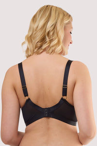Model shows the back of a kristina black quarter cup longline bra featuring adjustable satin shoulder straps with hook-and-eye fastening back.