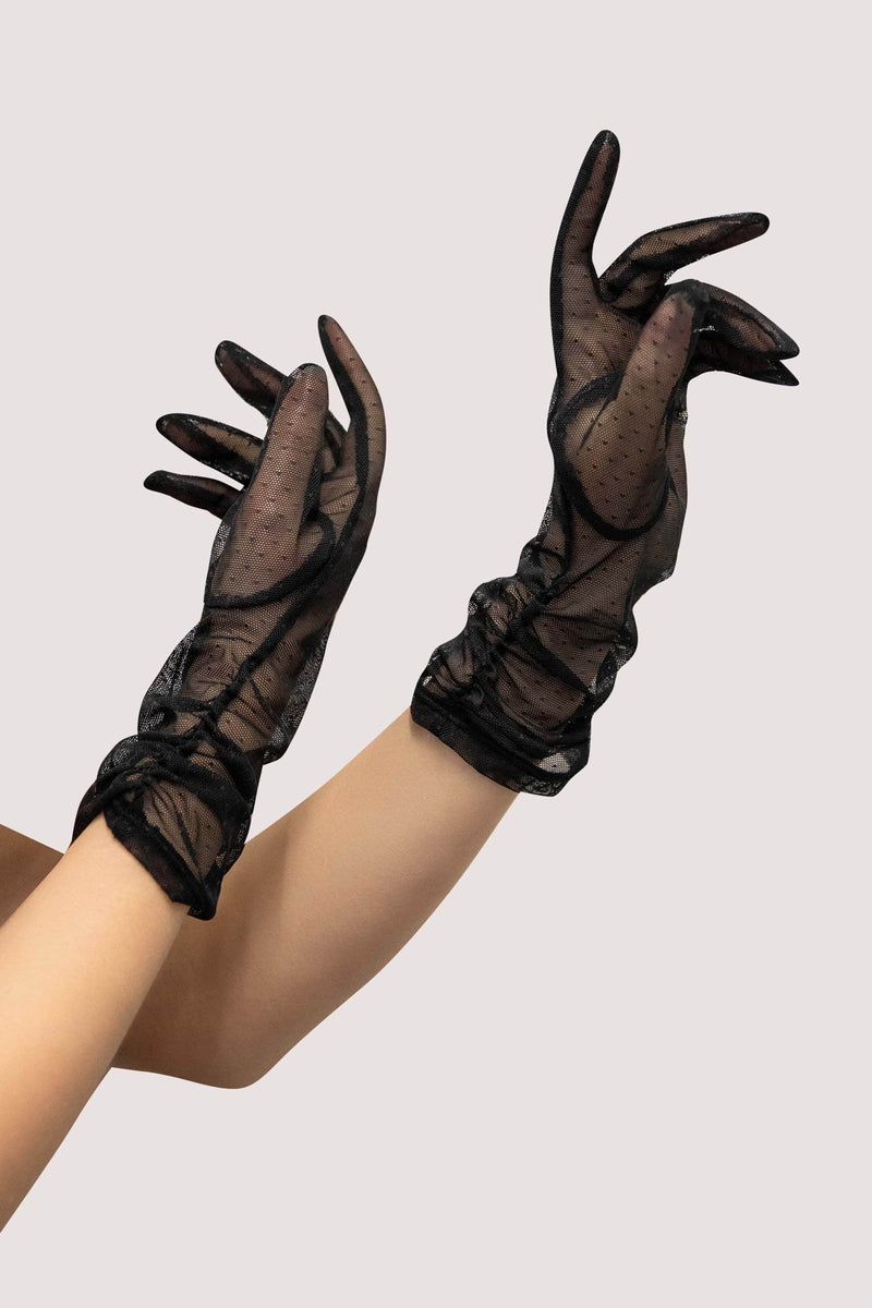 Model wears black sheer mesh gloves with polka dots and wrist frill