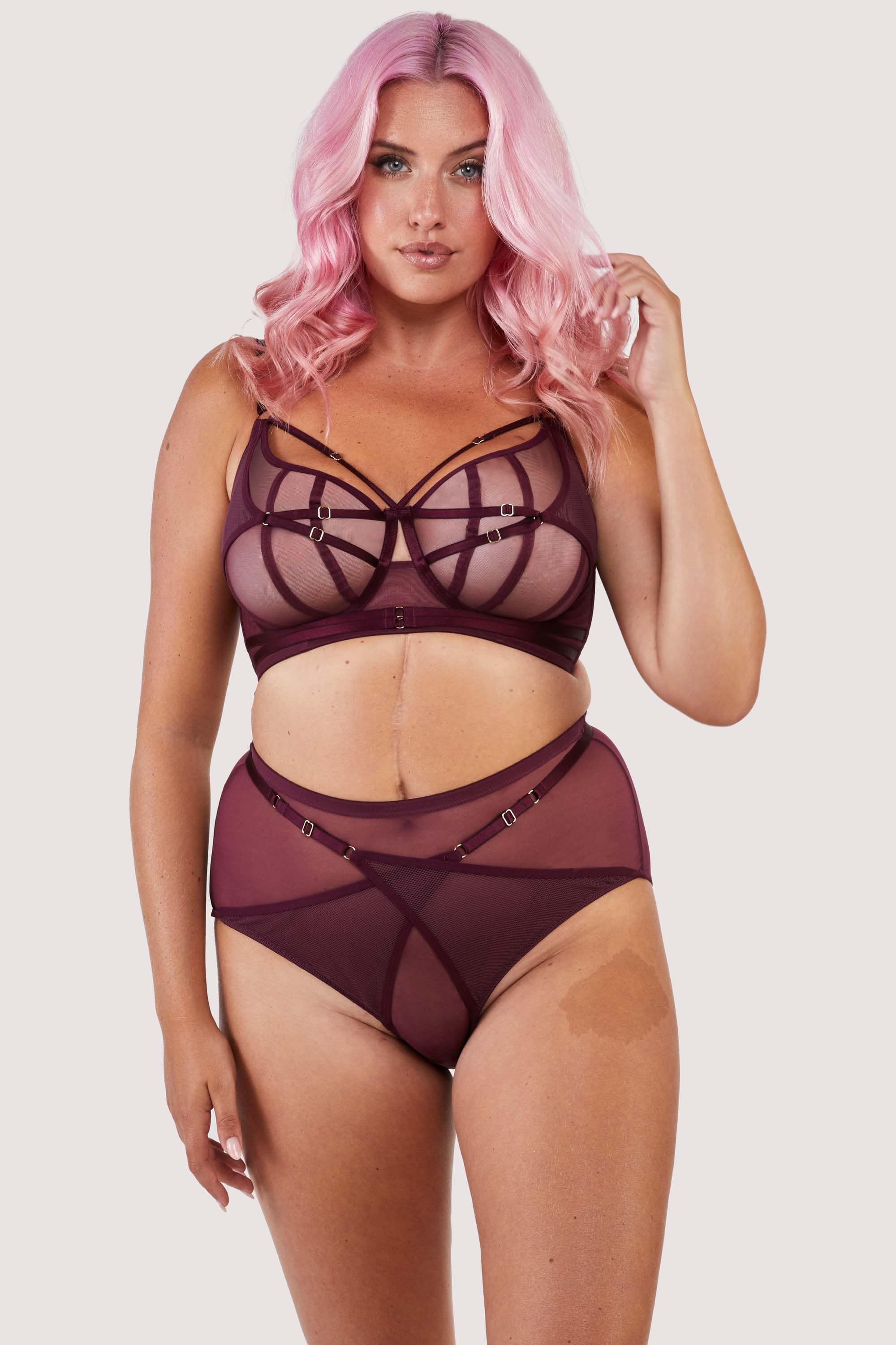 Harness style bra and brief with mesh overlay and visible gold hardware in a deep wine red/purple.