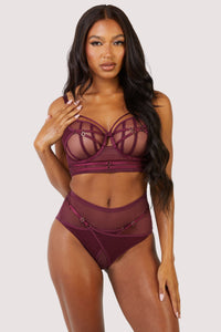 Harness style brief with mesh overlay and visible gold hardware in a deep wine red/purple, worn with matching bra.
