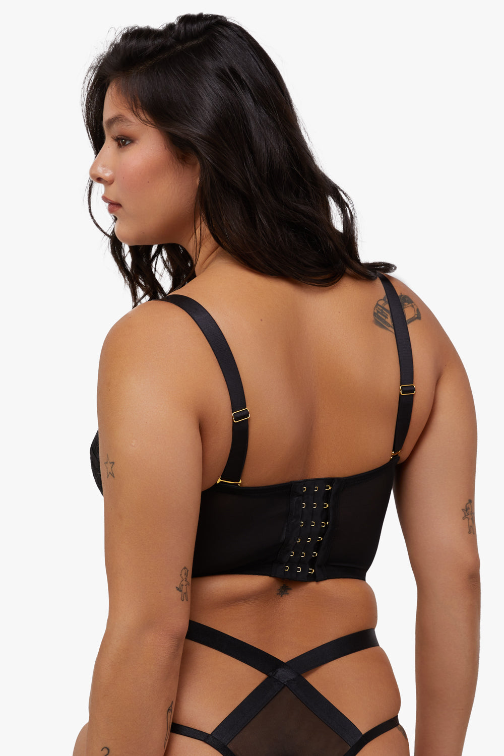 Model shows hook and eye fastening back and adjustable shoulder straps of black mesh bustier