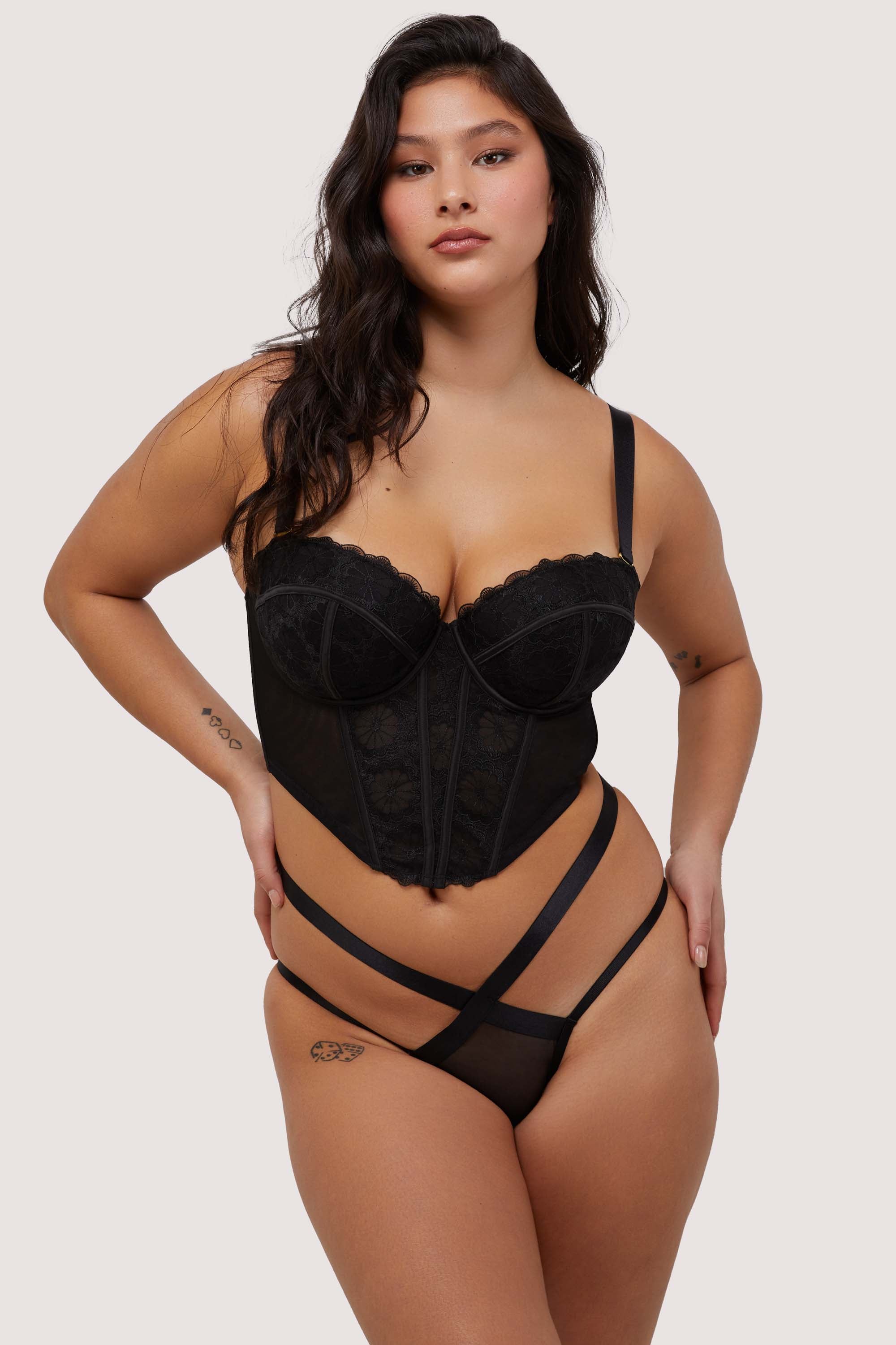 Model wears black embroidered mesh boned  bustier with removable shoulder straps and underwire cups