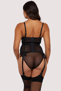 Model shows back of a black floral embroidery basque featuring adjustable suspenders and shoulder straps with a hook and eye fastening back.