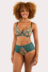 Model wears teal contrast embroidery balconette bra and high waisted brief set featuring nude mesh and teal floral detailing