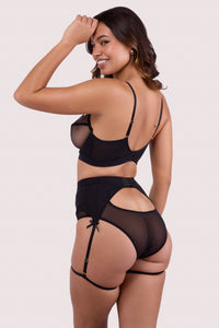 Model shows back of  black mesh suspender belt set with adjustable thigh straps and satin bow accents