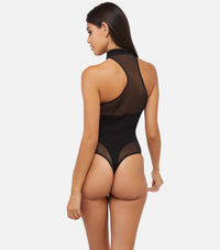 Model shows back of black asymmetric mesh and jersey bodysuit featuring sheer panel and high leg thong design