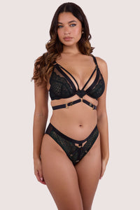 Model dark green wet-look lace plunge bra with strappy harness details and matching high-waisted brief