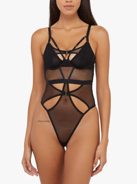 Model shows back of Black Micro Fishnet Bodysuit with harness straps, mesh panels, and thong-style bottom